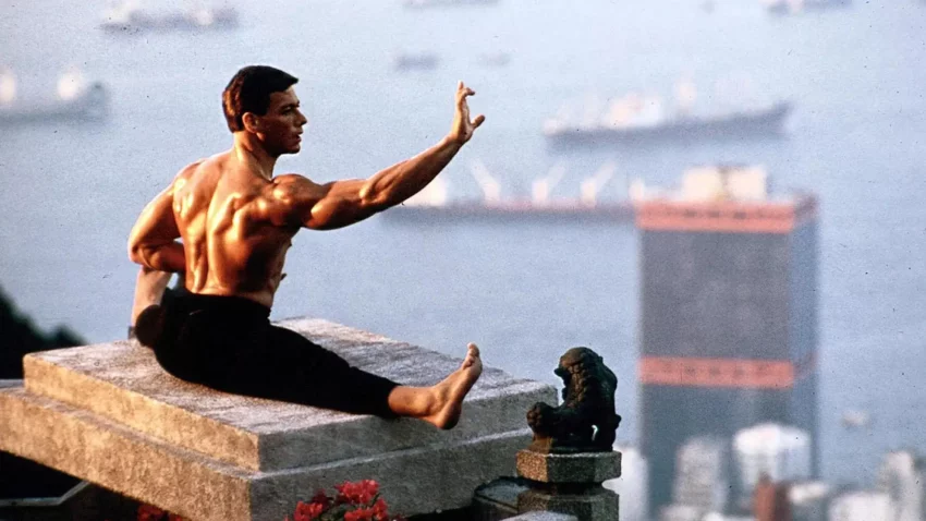 Photo de l'acteur Jean-Claude Van Damme en grand écart au sommet d'un building.